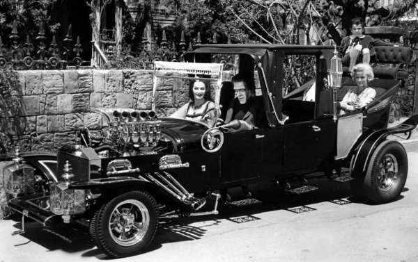 Канибализирайте части от три Model-T и една катафалка, комбинирайте ги по страховит, измамен начин и добавете детайли като дръжки на ковчежета, &bdquo;кървавочервена&ldquo; кадифена тапицерия и фарове с паяжина и ще получите т.нар. Munster Koach, идеалната кола за призрачно ситком семейство, където главата на семейството работи в погребален дом и прилича на чудовището на доктор Франкенщайн.

Създаден от известния холивудски специалист по персонализиране на автомобили Джордж Барис &ndash; на когото студиото дава само три седмици, за да разработи Munster Koach &ndash; дългият 5,48 м автомобил въпреки това включва редица ръчно оформени елементи, като месинговия радиатор и калниците. Използван е V8 двигател на Ford Cobra. Колата е управлявана от звездата на шоуто Фред Гуин, който е 2,13 м висок и играе ролята на Херман Мюнстър.
